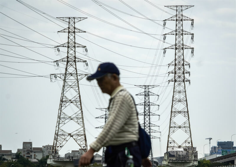 圖為民眾行經高壓電塔。(中央社檔案照片)