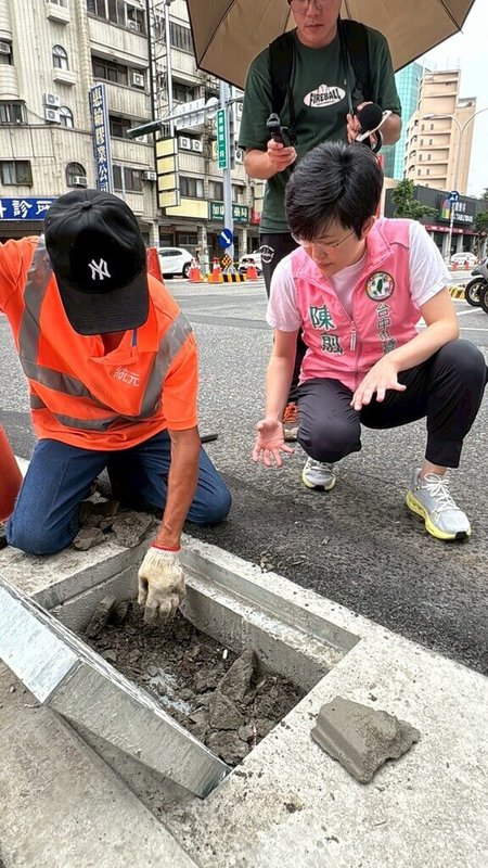 民進黨台中市議員陳俞融(前右)表示,北區崇德路一段及德化街口,近期施作人行道改善工程,但工程驗收完工後,水溝孔蓋卻被封住,且水溝蓋下沒有水溝,質疑難怪遇雨無法排水。(陳俞融提供)中央社記者郝雪卿傳真 114年7月6日