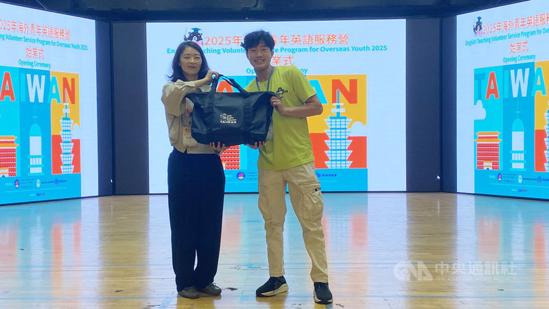僑務委員會、教育部國教署與客家委員會共同舉辦「2025海外青年英語服務營」7日上午在亞洲大學舉行始業式,僑生處科長徐廣梅(左)代表致贈紀念品給志工。中央社記者趙麗妍攝  114年7月7日