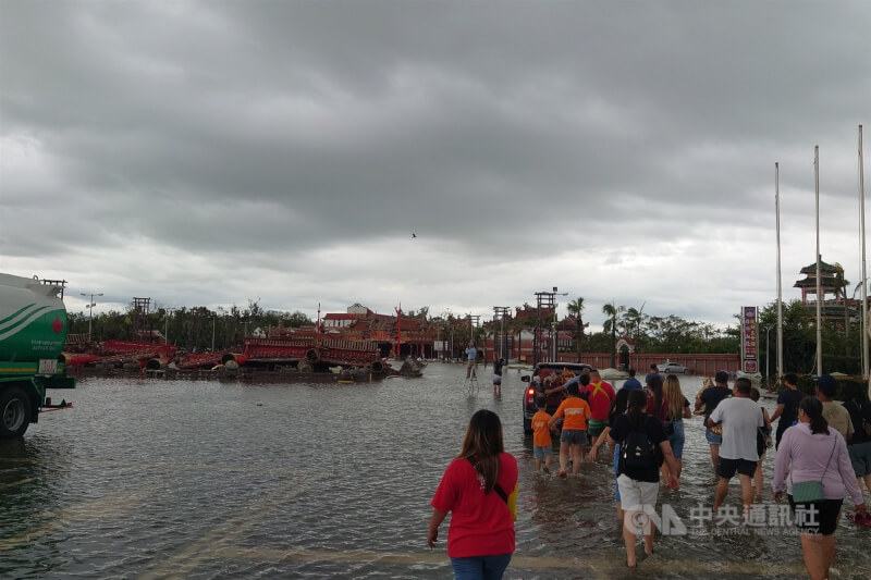 台南市北門區南鯤鯓代天府知名地標大牌樓不敵颱風丹娜絲風雨倒塌,7日廟前雖仍有積淹水,還是有進香團涉水前去進香。中央社記者楊思瑞攝 114年7月7日