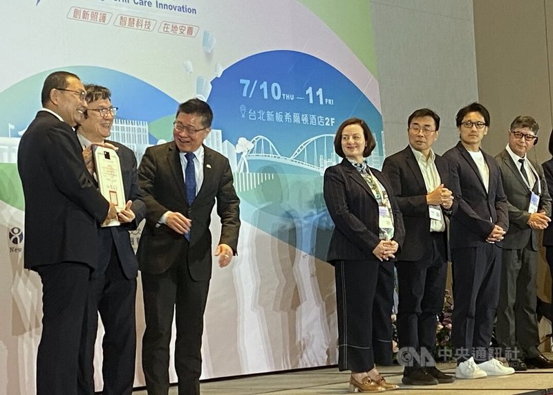 2025長照創新國際研討會10日在板橋舉行，新北市長侯友宜（左）頒發獎狀給參與論壇的國內外學者及政策代表，包括衛福部政務次長呂建德（左3）等人入列。中央社記者黃旭昇新北攝  114年7月10日