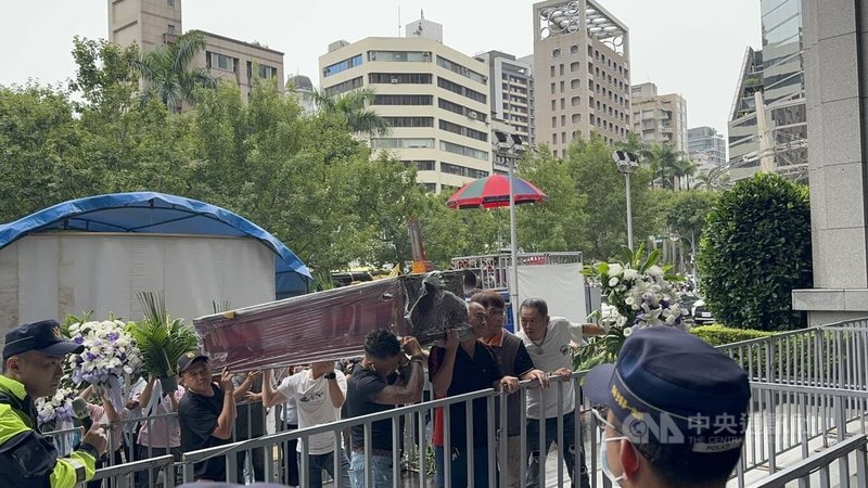 不滿明年起強制遊覽車裝設具有駕駛識別功能設備的新規定,新北市遊覽車駕駛員職業工會10日在交通部門前抗議,駕駛們抬著棺材、撒冥紙表達抗議訴求。中央社記者余曉涵攝 114年7月10日