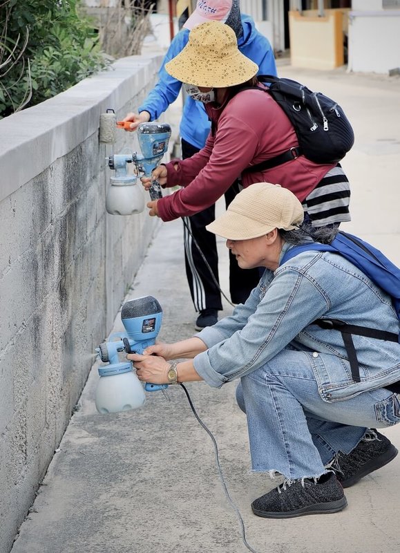 DIY工作坊學員運用成大昶閎研發的在地材料「樂土細蚵灰」,以噴塗、滾塗技法為澎湖紅羅社區改造牆面。(成大昶閎提供)中央社記者蘇筱雯傳真 114年7月10日