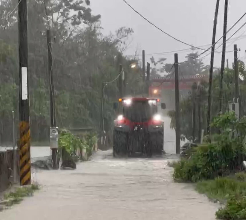 屏東里港鄉中和路有民眾10日上午要去診所,但家門口水深過膝,車輛無法開出,最後請友人開來大型農車才順利出門就醫。(王姓民眾提供)中央社記者李卉婷傳真 114年7月10日