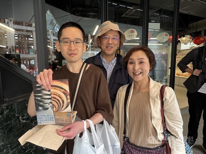 圖為來自廣島一家三口6月11日特地來參觀TECH WORLD館,其中兒子(左)手持1970年大阪首次、也是亞洲國家首次辦世博時中華民國館的宣傳品。中央社記者楊明珠大阪攝 114年7月11日