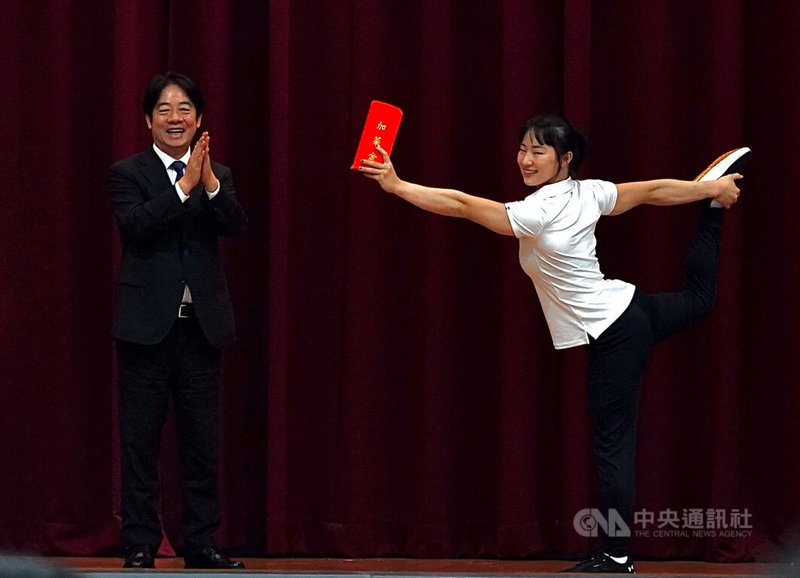 「2025年第32屆萊茵魯爾世界大學運動會代表團授旗典禮」11日上午舉行,總統賴清德(左)致贈加菜金,由體操好手「體操精靈」丁華恬(右)代表接受。中央社記者董俊志攝 114年7月11日