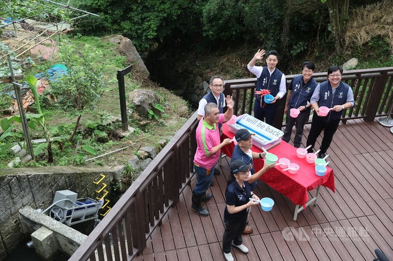 台北市首座聚落式污水處理設施14日在內湖白石湖地區正式啟用,收集附近建築物的污水,經妥善淨化處理後再放流至溪溝,並結合水力及太陽能之綠電互補系統,以改善環境衛生及河川溪流水質。圖為蔣萬安(後右3)回放小魚。中央社記者王飛華攝 114年7月14日