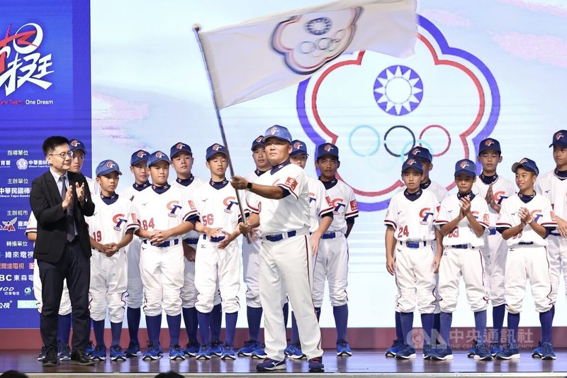 2025三級棒球國家代表隊誓師大會14日下午在台北福華大飯店舉行,U12代表隊總教練章子健(前中)接下會旗揮舞,盼能率隊為國爭光。中央社記者翁睿坤攝 114年7月14日