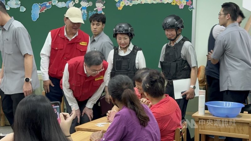 中部地區15日下午舉行2025城鎮韌性防空演習,行政院長卓榮泰(中左戴眼鏡者)出席台中場次視察演練,並到災民收容區關心扮演災民的民眾,台中市長盧秀燕(後中)陪同。中央社記者趙麗妍攝 114年7月15日