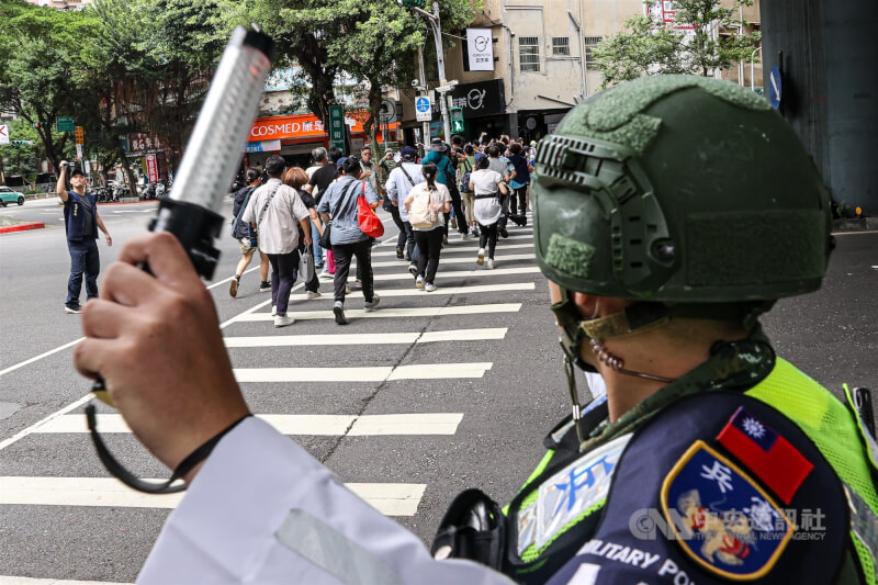 圖為演習開始後,民眾在憲兵指引下進行疏散,快速過馬路。(中央社檔案照片)