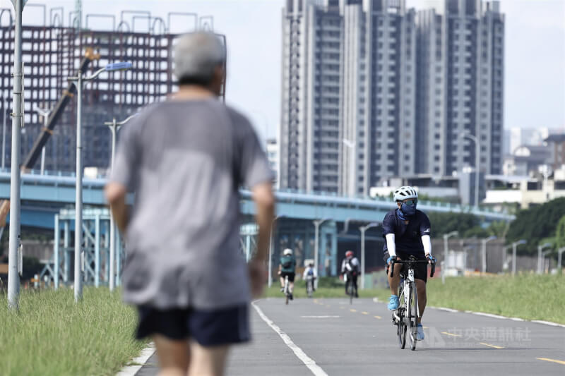 圖為台北市松山區民眾穿著防曬裝備騎腳踏車運動。(中央社檔案照片)