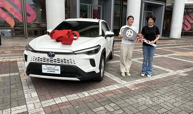 李姓女子（左）日前參加台東縣池上鄉活動並住宿，業者告知可參加抽獎活動，結果幸運抽中最大獎、油電車一輛，16日開心從台東縣長饒慶鈴（右）手中象徵性接過車鑰匙。中央社記者盧太城台東攝　114年7月16日