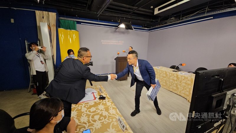 新北市第1選舉區立委洪孟楷罷免案16日進行電視說明會,國民黨立委洪孟楷(前右)與罷團領銜人方柏翔(前左2)握手致意。中央社記者王鴻國攝 114年7月16日