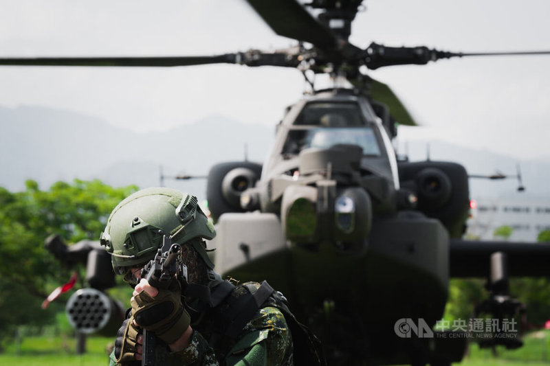 AH-64E阿帕契攻擊直升機實施熱加油及掛彈演練,官兵持槍在旁警戒。中央社記者游凱翔攝 114年7月17日