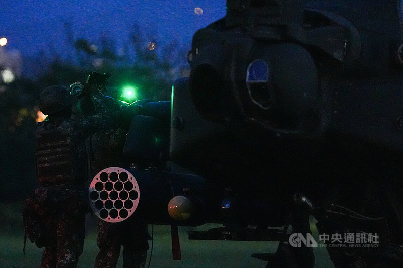 AH-64E阿帕契攻擊直升機17日晚間實施夜間熱加油及掛彈訓練,圖為操演官兵替阿帕契掛載武器彈藥。中央社記者游凱翔攝 114年7月17日