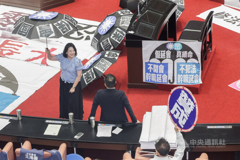 立法院會18日處理民眾黨團提案,建請立法院再延長會期至8月31日止。雖然民進黨立委反對,但院會表決處理時仍不敵藍白人數優勢,最終表決通過。圖為表決時,民進黨團幹事長吳思瑤(左)手舉雨傘,批延會是將司法保護傘撐好撐滿。中央社記者裴禛攝 114年7月18日