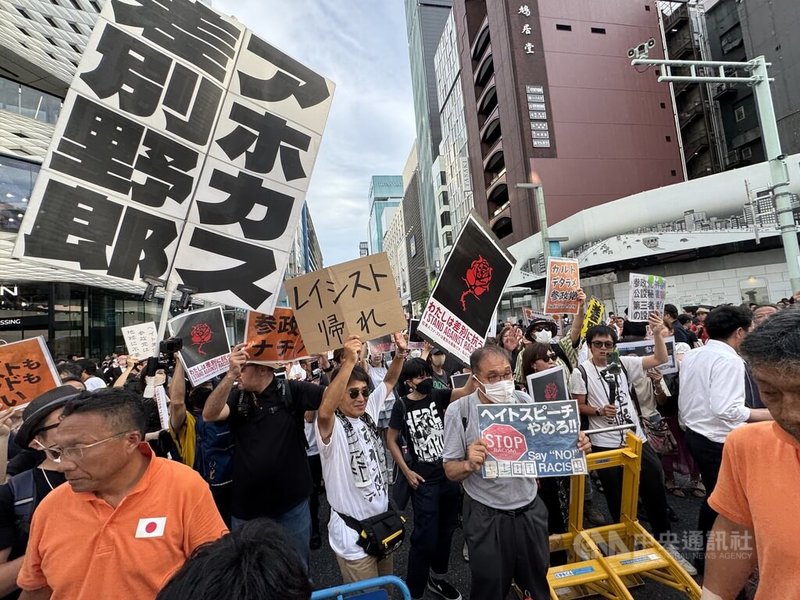 日本參議院大選20日投開票,各政黨19日進行最後衝刺。參政黨候選人在銀座發表街頭演說時,有反對者高舉「蠢渣!搞歧視的王八蛋!」等抗議標語。中央社記者楊明珠東京攝 114年7月19日