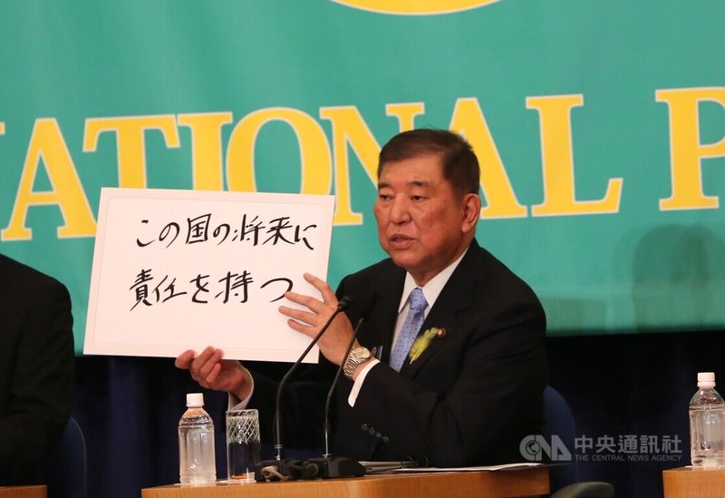 日本參議院選舉將於20日投開票,8個政黨黨主席2日出席在日本記者俱樂部主辦的辯論會,自民黨總裁(黨主席)、首相石破茂舉出寫著「要為這國家的將來負責」的政見牌。中央社記者楊明珠東京攝 114年7月19日