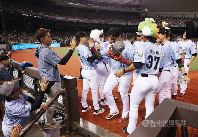 中職明星賽20日進入第2天,43歲林智勝(前右2)日擔任TEAM TAIWAN先發游擊手、打第2棒,守了整整7局,8局上完成1個出局後退場,也受到全場球迷歡呼,回到休息區隊友上前致意。中央社記者張新偉攝 114年7月20日
