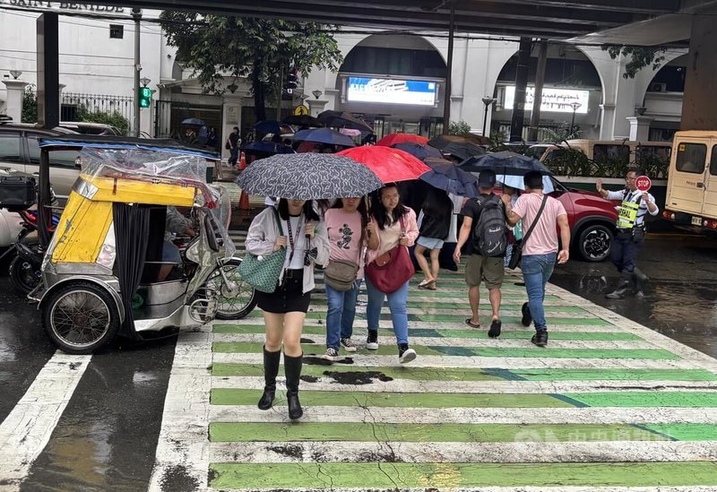 菲律賓大馬尼拉地區近日受到西南季風影響下起大雨,菲律賓氣象局21日發布「橘色」降雨警示。圖為馬尼拉市雨中景象。中央社記者林行健馬尼拉攝 114年7月21日