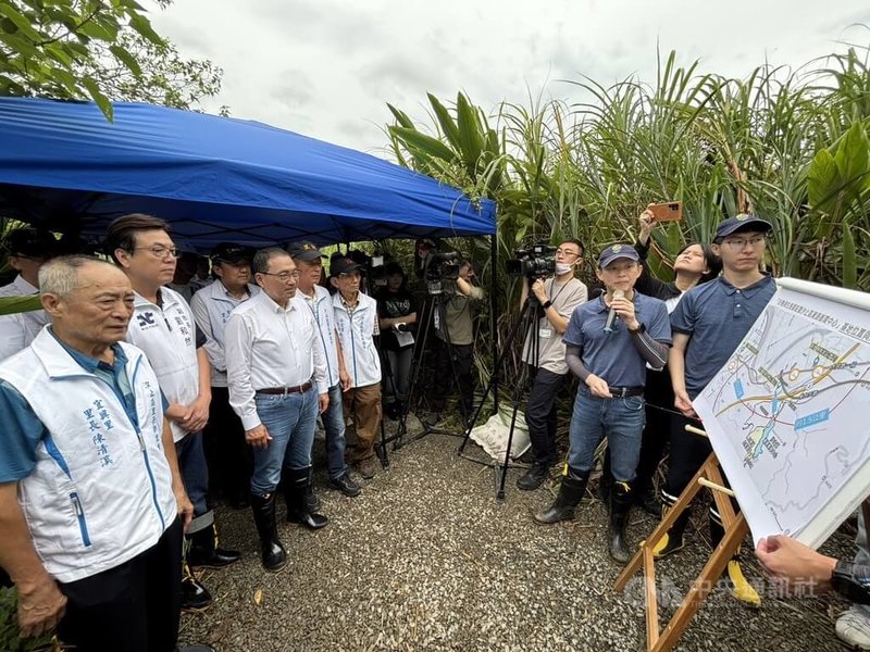 新北市長侯友宜(前左3)22日赴汐止區白匏湖視察時表示,市府推動白匏湖生態園區整建並整合周邊,讓白匏湖與北側谷地成為低海拔保育類動物的棲地。圖為侯友宜聽取簡報。中央社記者趙敏雅攝 114年7月22日