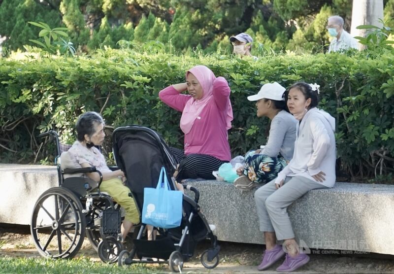 圖為家庭看護移工與雇主在高雄市一處公園內休憩。(中央社檔案照片)