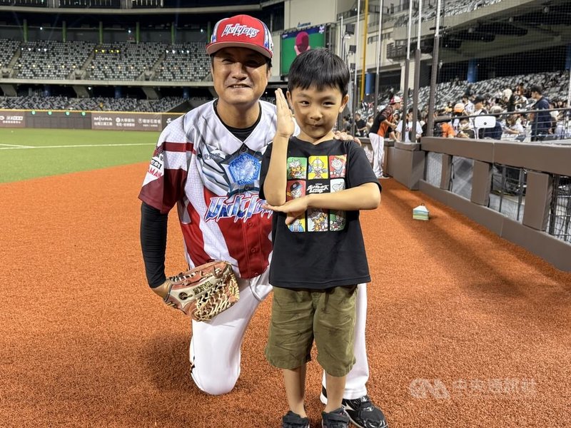 中華職棒統一7-ELEVEn獅隊「超人力霸王」主題日登場,25日安排打擊教練潘武雄(左)5歲小兒子潘緯宸(前右)開球,拍合照時,潘緯宸馬上比出「超人力霸王」招牌手勢。中央社記者謝靜雯攝 114年7月25日