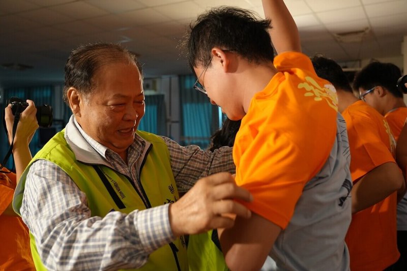 澎湖縣長陳光復（左）24日晚間為台北醫學大學楓杏社會醫療服務隊成員舉行授服儀式，並為團隊成員穿上象徵使命的楓杏服務衣服，感謝北醫楓杏醫療服務隊15年來在澎湖偏鄉行醫療巡迴義診服務。（澎湖縣政府提供）中央社   114年7月25日