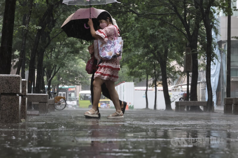 圖為台北市信義區民眾撐傘避雨。中央社記者翁睿坤攝　114年7月25日