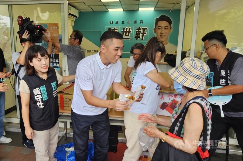 首波大罷免全遭否決,台灣民眾黨籍新北市議員陳世軒(前左2)27日下午在北新莊服務處發放雞排、冰棒及飲料等,吸引民眾領取。中央社記者王鴻國攝 114年7月27日