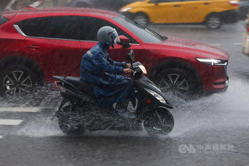 圖為新北市土城區午後下起大雨,街頭車輛通過積水濺起水花。(中央社檔案照片)