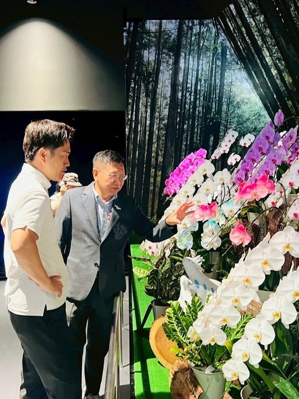大阪府知事吉村洋文（前）26日造訪大阪世博TECH WORLD館，館長邱揮立（後）特別介紹台灣引以為傲的蘭花產業，指出全球市場約1/3的蘭花來自台灣。（TECH WORLD館提供）中央社記者戴雅真東京傳真　114年7月27日