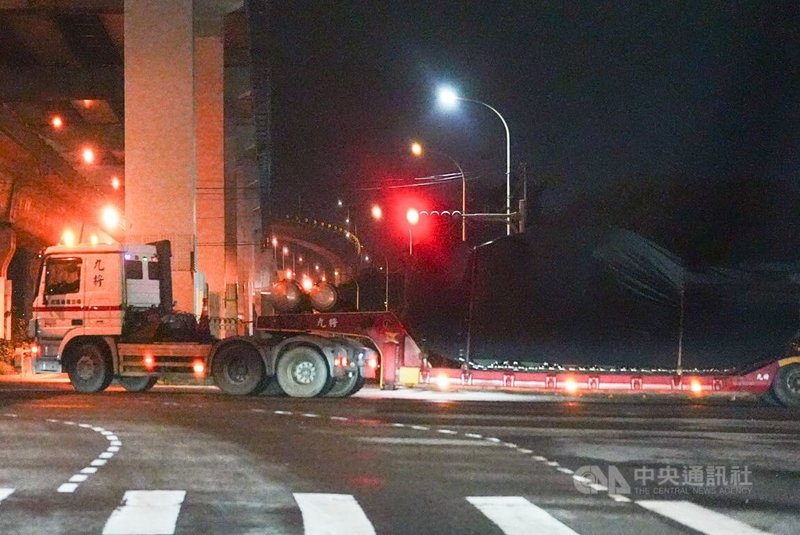 第2批M1A2T戰車27日晚間運抵台北港後,以板運方式送至新竹裝訓部。圖為裝載M1A2T的卡車於28日凌晨離開港區大門時,憲兵進行交管。中央社記者游凱翔攝 114年7月28日