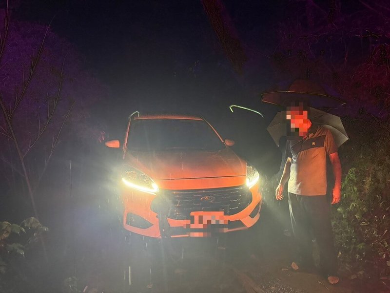 民眾駕車欲投宿台中東勢山區一家民宿,因產業道路狹小、路燈昏暗又下大雨,車輪卡在邊坡,幸獲員警相助脫困。(民眾提供)中央社記者趙麗妍傳真 114年7月29日