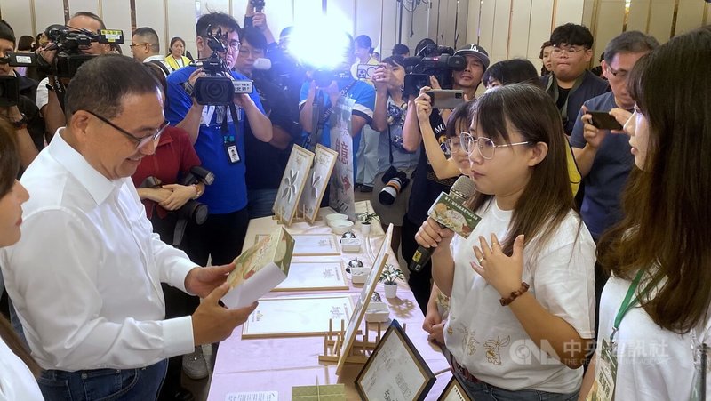 第12屆新北庇護禮發表記者會29日舉行,新北市長侯友宜(前左)出席並聽取醒吾科技大學團隊成員介紹茶餅禮盒的外包裝設計理念。中央社記者黃旭昇新北市攝 114年7月29日