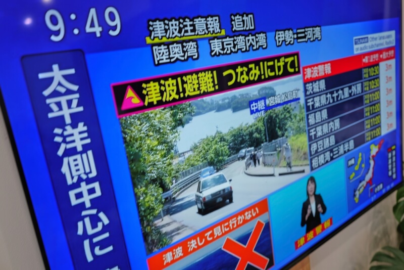 俄羅斯遠東地區外海30日發生強烈地震,日本太平洋沿岸發布海嘯警報,電視新聞畫面提醒民眾避難。(美聯社)