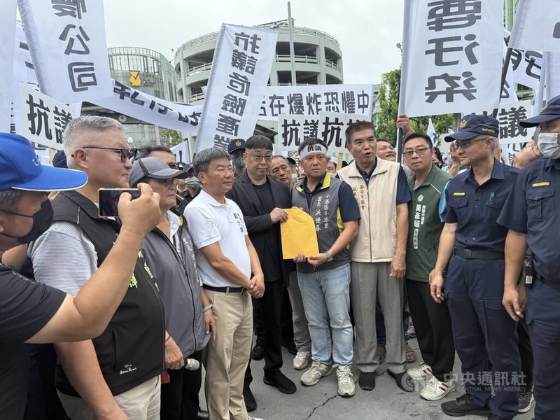 台泥旗下三元能源公司鋰電池工廠14日發生火災，引發安全疑慮。高雄民眾30日前往位於小港區的廠區外抗議，三元能源總經理薛人禎（前左5）親自出面致歉，並接下抗議陳情書。中央社記者董俊志攝  114年7月30日