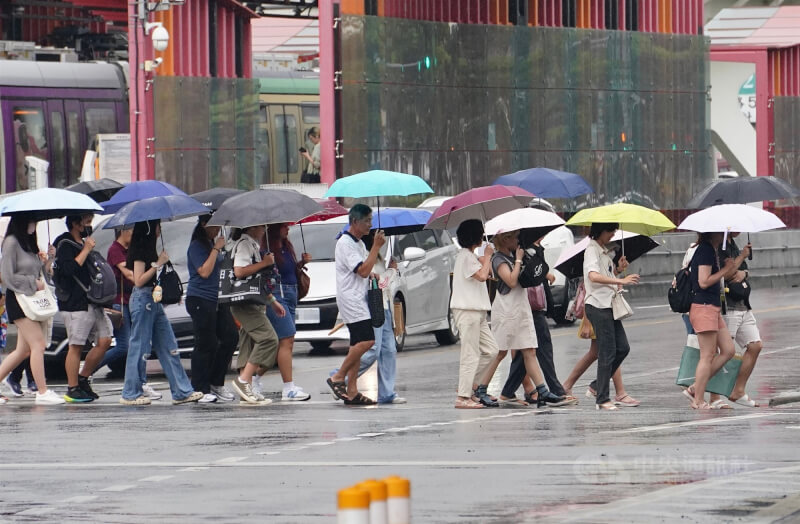 圖為高雄市前鎮區民眾撐傘遮擋雨勢。(中央社檔案照片)