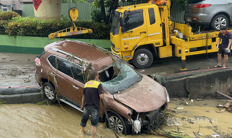 彰化地區30日晚間降下大雨,彰化市香山里道路淹水,先後有6輛汽車遭沖入排水溝涵洞、防洪道,31日中午已出動拖吊車協助將車輛吊出。中央社記者吳哲豪彰化攝 114年7月31日