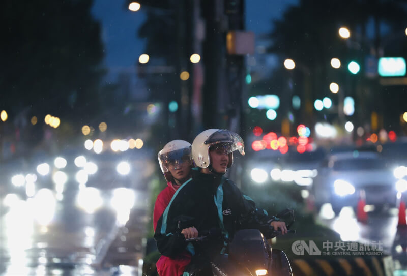 圖為大台北地區1日傍晚下午雷陣雨，雨勢一直持續至入夜都還沒完全停止，街頭民眾穿起雨衣騎車穿梭在車陣中。（中央社檔案照片）