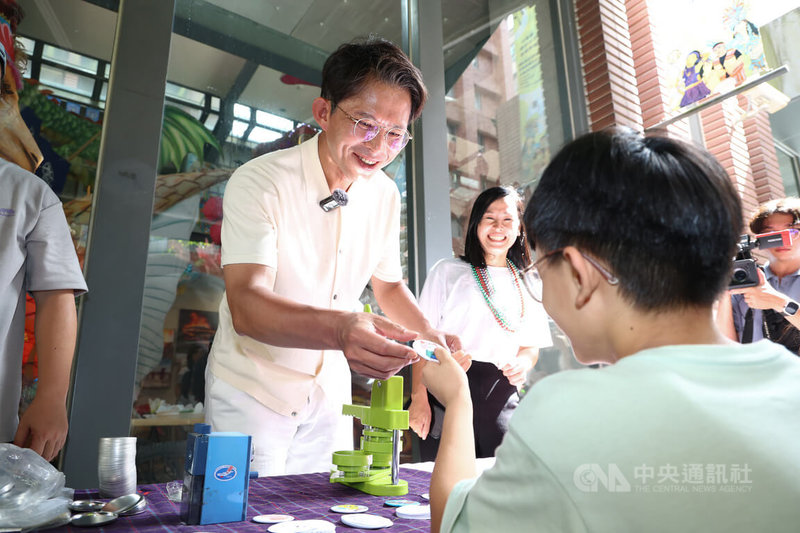 民眾黨主席黃國昌(後白衣)3日下午出席新北汐止充氣城堡童樂會,黃國昌幫現場小朋友製作磁鐵,並與小朋友開心互動。中央社記者翁睿坤攝 114年8月3日