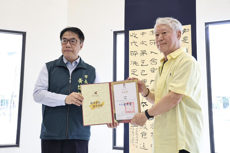 颱風丹娜絲造成台南多處災損，藝術家蔣勳（右）捐出一幅書法作品「金剛經」立軸義賣，台南市長黃偉哲（左）5日回贈感謝狀。（台南市政府提供）中央社記者楊思瑞台南傳真　114年8月5日
