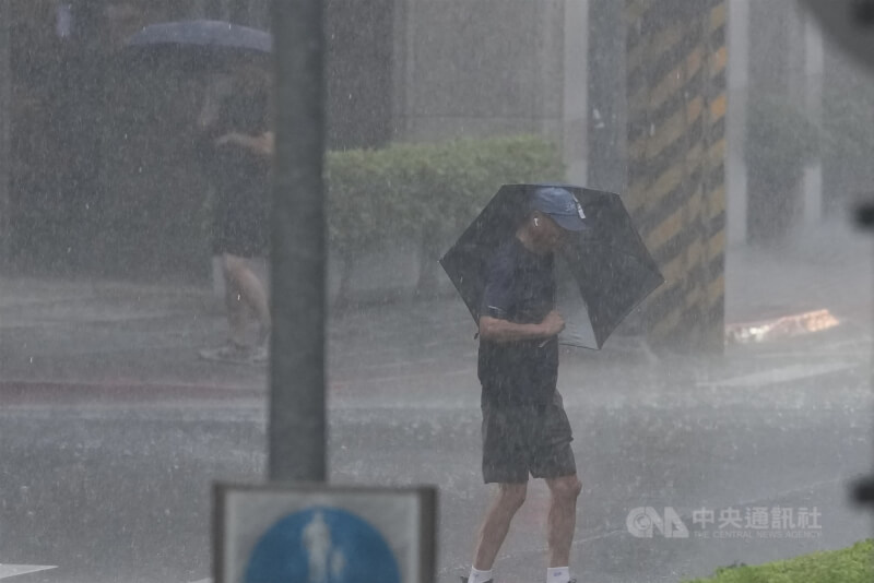 中央氣象署5日發布大雨特報，北北基等6縣市防局部大雨。圖為台北市北投區外出民眾遇到傾盆大雨。中央社記者徐肇昌攝　114年8月5日