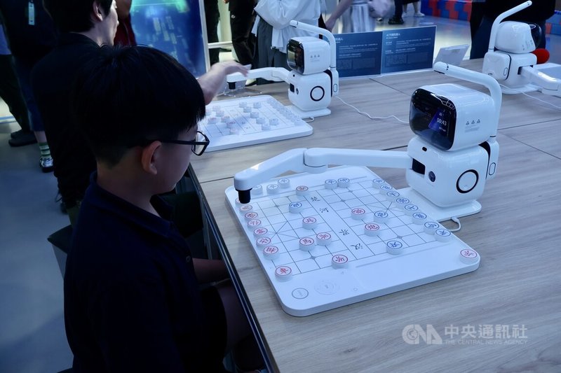 全球首個以具身智慧機器人為核心的4S店在北京亮相。圖為兒童與店內展示的下棋機器人對弈。中央社記者謝怡璇北京攝 114年8月6日