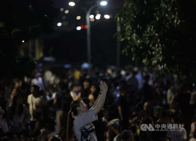 現場聚集大批觀賞人潮,民眾拿起手機拍下被煙火點亮的夜空。中央社記者趙世勳攝 114年8月6日