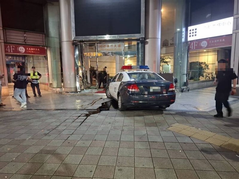 台北市大安警分局員警7日凌晨開警用汽車赴忠孝東路4段附近大樓處理糾紛案時,疑煞車失靈,車輛直衝大樓撞擊門柱後才停住,導致大門玻璃破碎,造成2名民眾雙腿被玻璃割傷。(警方提供)中央社記者劉建邦傳真 114年8月7日
