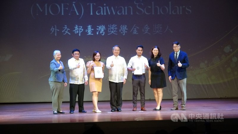 駐菲律賓代表處7日頒發台灣獎學金,今年首次納入外交部台灣獎學金,深化台菲教育交流與人才培育合作。圖為駐菲代表周民淦(中)、代表處官員、菲律賓政府官員以及兩名受獎生合影。中央社記者林行健馬尼拉攝 114年8月7日