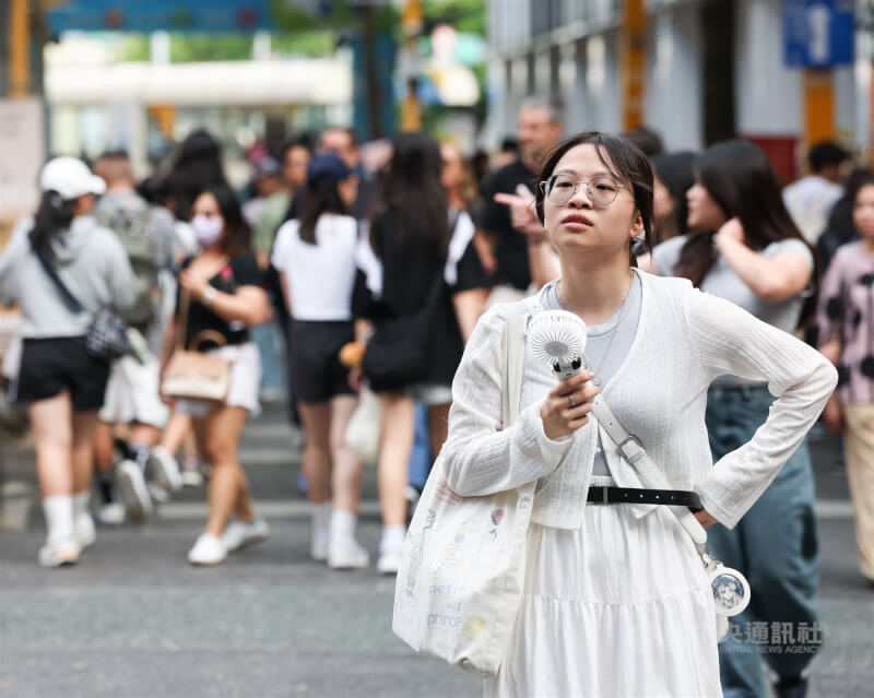 圖為台北市西門町商圈午後逛街民眾手持小風扇消暑。（中央社檔案照片）
