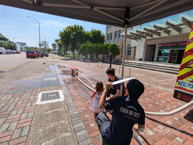 台中市消防局8日舉辦「消防帥老爸」親子主題活動,邀請消防員與孩子一同參與,透過射水滅火關卡,讓孩童體驗父親的工作日常。中央社記者蘇木春攝 114年8月8日