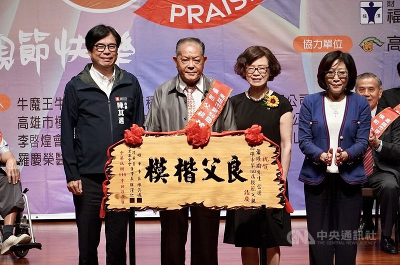 高雄114年慶祝父親節暨第50屆模範父親表揚活動8日上午舉行，市長陳其邁（左）頒贈「良父楷模」賀匾給今年獲選的26名模範父親，表達敬意，並祝福爸爸們父親節快樂。中央社記者董俊志攝　114年8月8日